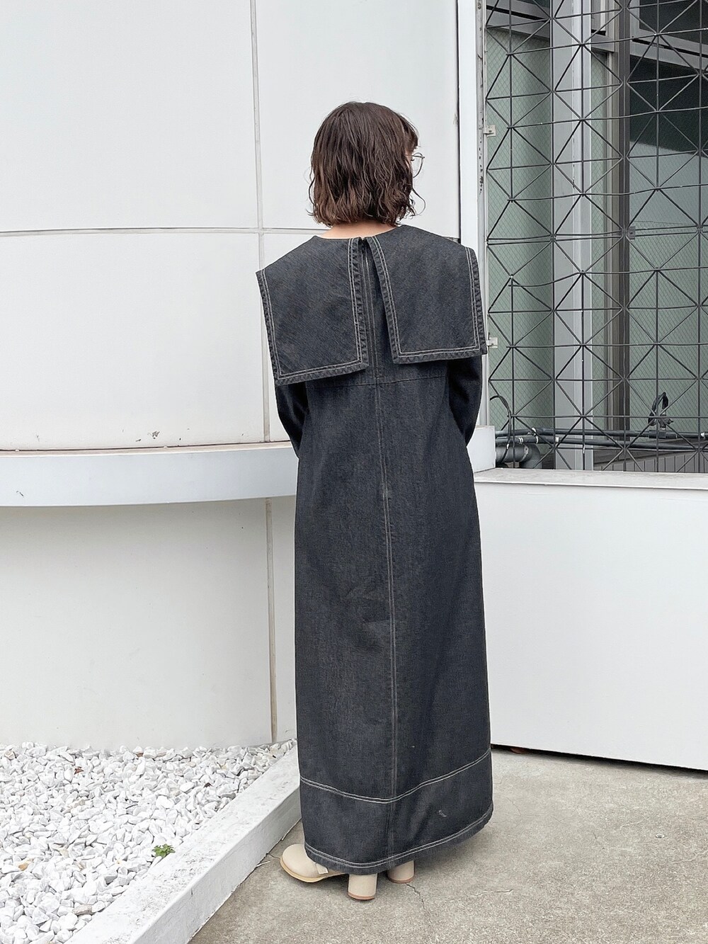 ブラック系のワンピース、ベージュ系のブーツを着用したレディースの冬コーディネートの3枚目の写真