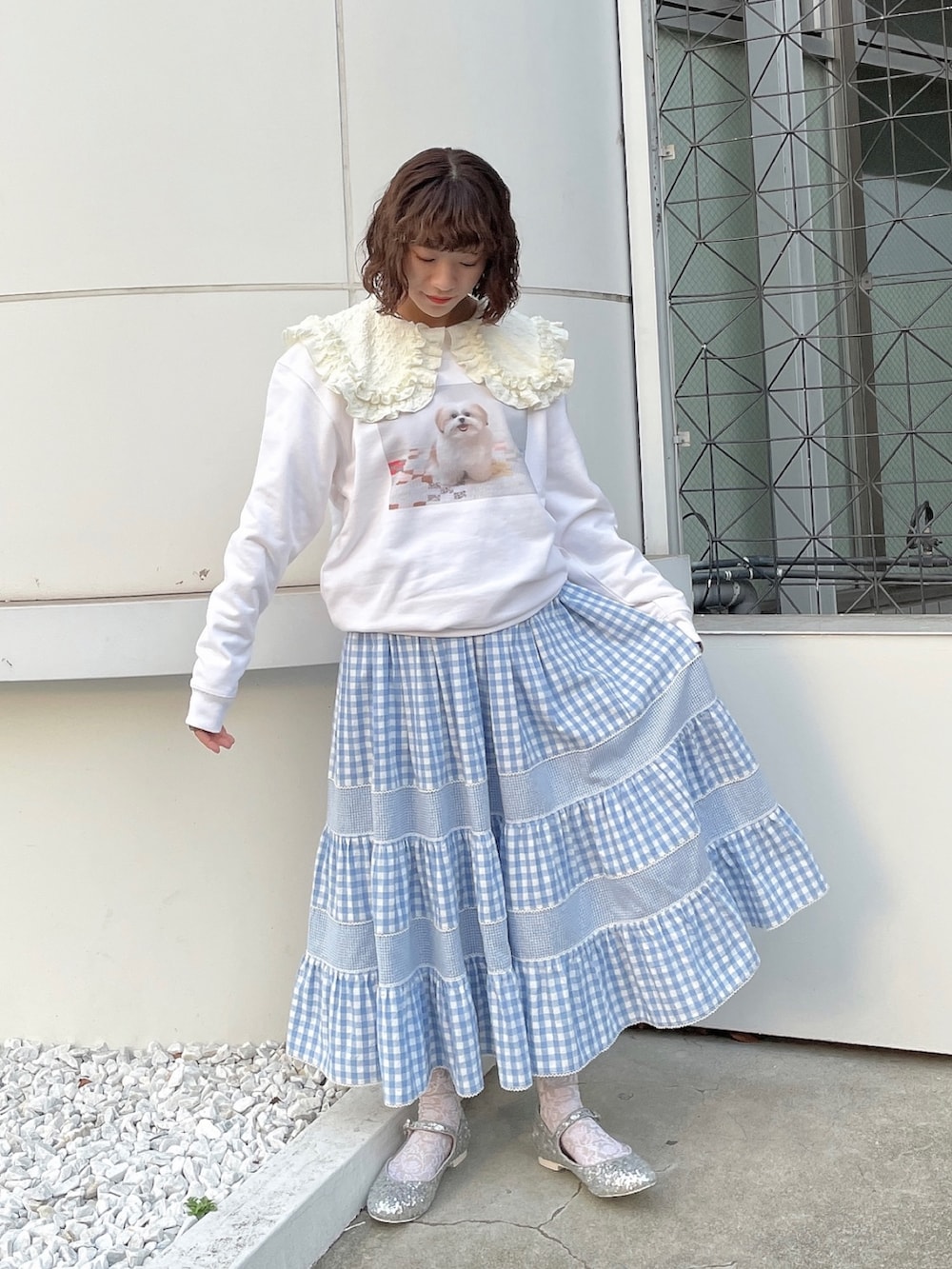 ホワイト系のスウェット、ホワイト系のTシャツ/カットソー、ブルー系のスカートを着用したレディースの冬コーディネートの2枚目の写真