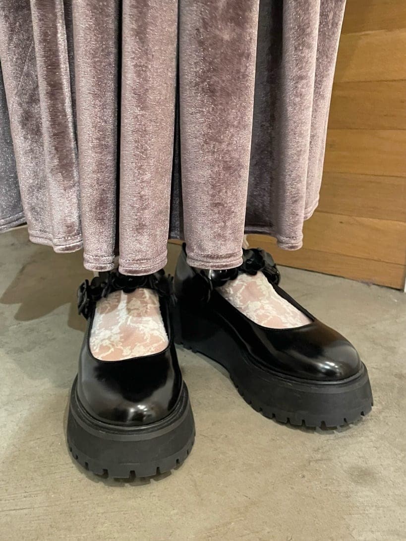 パープル系のスカート、ブラック系のローファー、ブラック系のステンカラーコートを着用したレディースの秋コーディネートの4枚目の写真