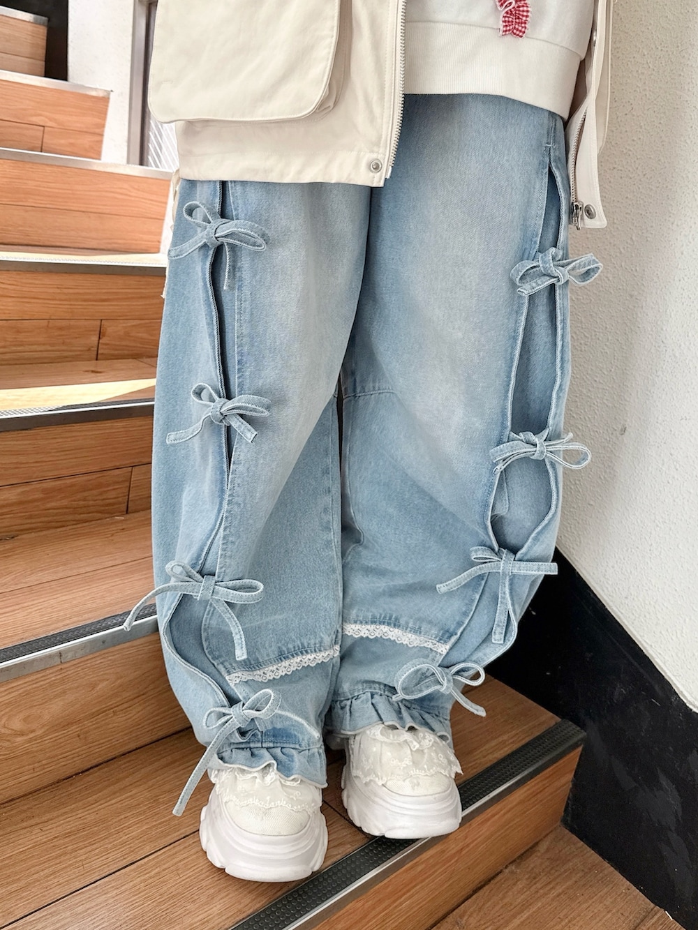 ホワイト系のブルゾン、ホワイト系のスウェット、ブルー系のデニムパンツを着用したレディースの冬コーディネートの9枚目の写真