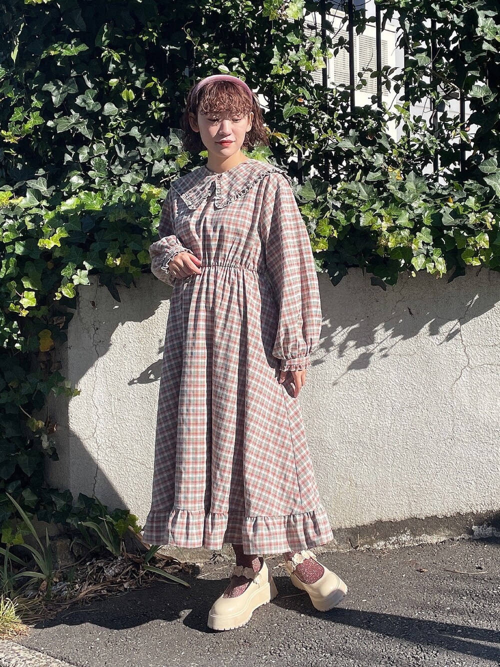 ホワイト系のカーディガン/ボレロ、ピンク系のワンピース、ホワイト系のローファーを着用したレディースの冬コーディネートの6枚目の写真