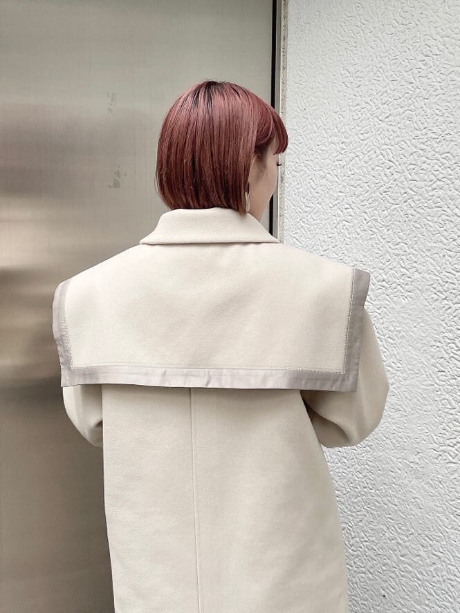 ホワイト系のニット/セーター、ホワイト系のその他アウター、ブラウン系のスカートを着用したレディースの秋コーディネートの4枚目の写真