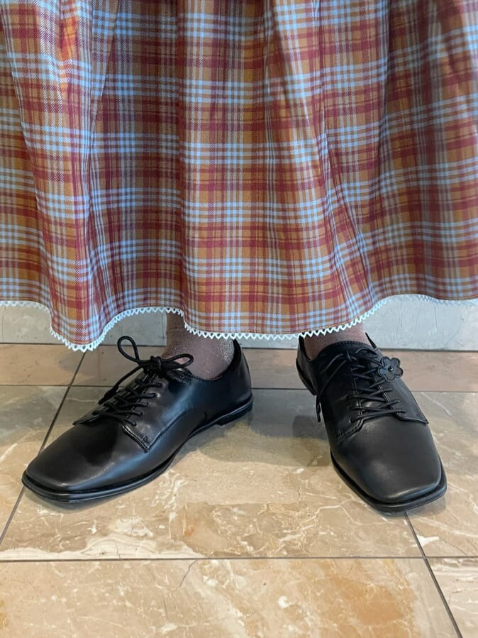 ブラック系のその他シューズ、ピンク系のTシャツ/カットソー、オレンジ系のスカートを着用したレディースの秋コーディネートの6枚目の写真