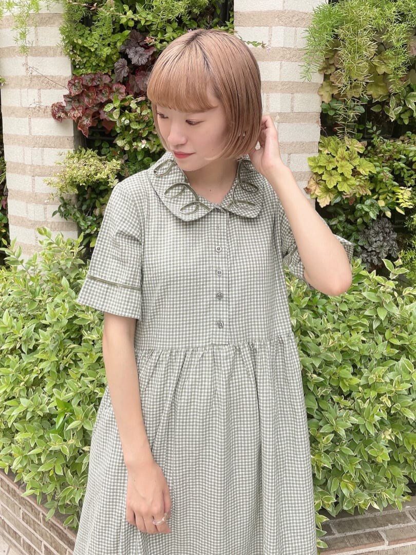 グリーン系のワンピース、ホワイト系のスニーカー、ホワイト系のハンドバッグを着用したレディースの夏コーディネートの3枚目の写真