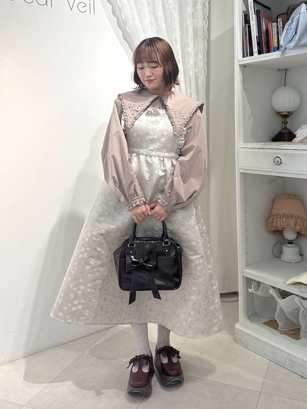 ベージュ系のシャツ/ブラウス、ホワイト系のワンピース、ブラウン系のハンドバッグを着用したレディースの夏コーディネートの2枚目の写真