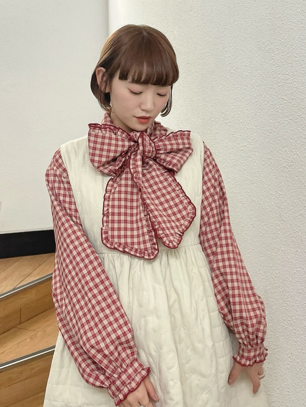 ホワイト系のダウンジャケット/コート、レッド系のシャツ/ブラウス、ホワイト系のワンピースを着用したレディースの冬コーディネートの10枚目の写真