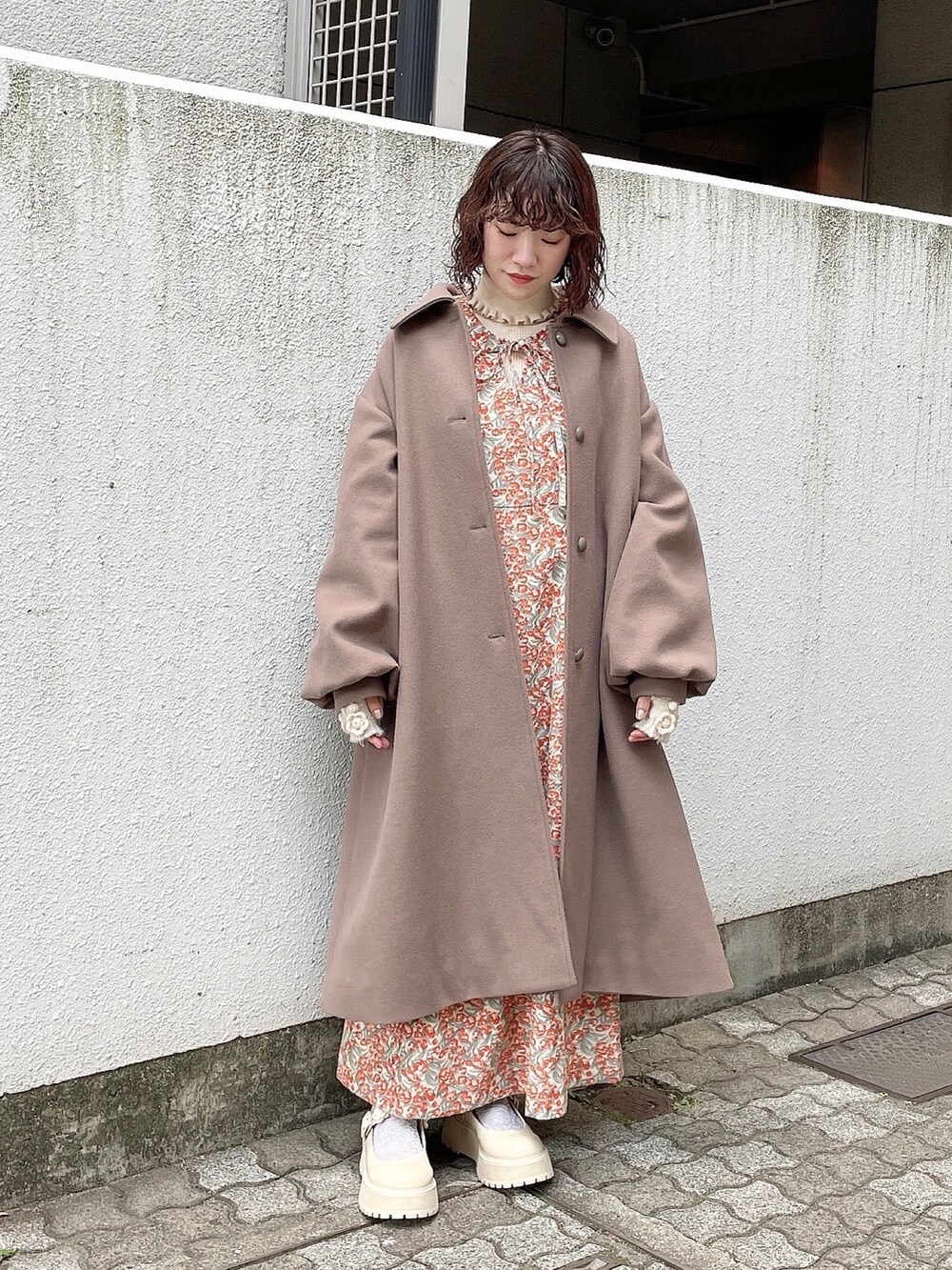 ブラウン系のその他アウター、ホワイト系のニット/セーター、オレンジ系のワンピースを着用したレディースの秋コーディネートの2枚目の写真