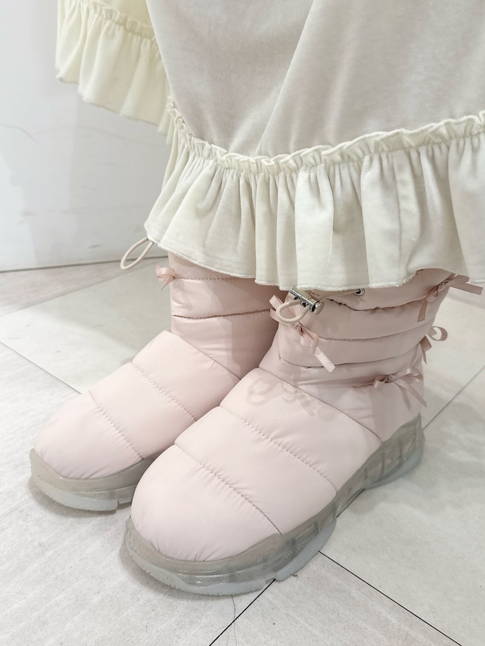 ピンク系のブーツ、ピンク系のカーディガン/ボレロ、ホワイト系のワンピースを着用したレディースの秋コーディネートの8枚目の写真