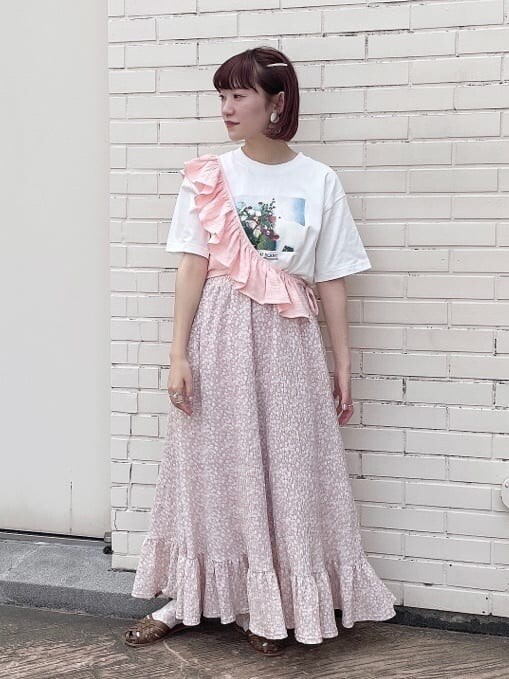 ピンク系のスカート、ベージュ系のパンプス、ホワイト系のTシャツ/カットソーを着用したレディースの夏コーディネートの2枚目の写真