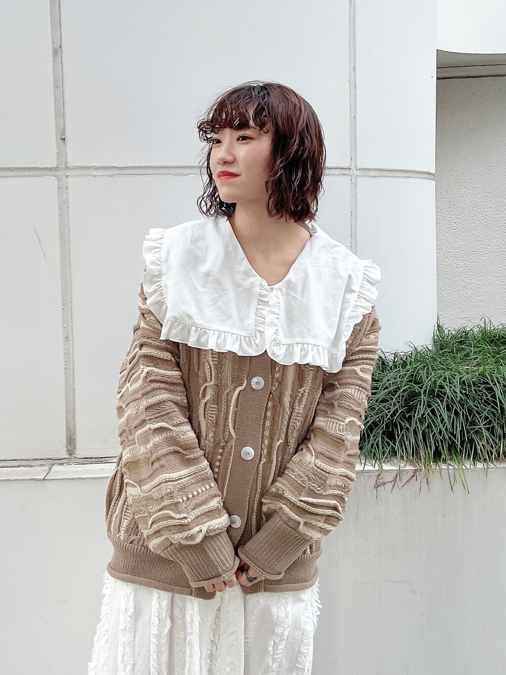 ベージュ系のカーディガン/ボレロ、ホワイト系のシャツ/ブラウス、ホワイト系のワンピースを着用したレディースの秋コーディネートの3枚目の写真