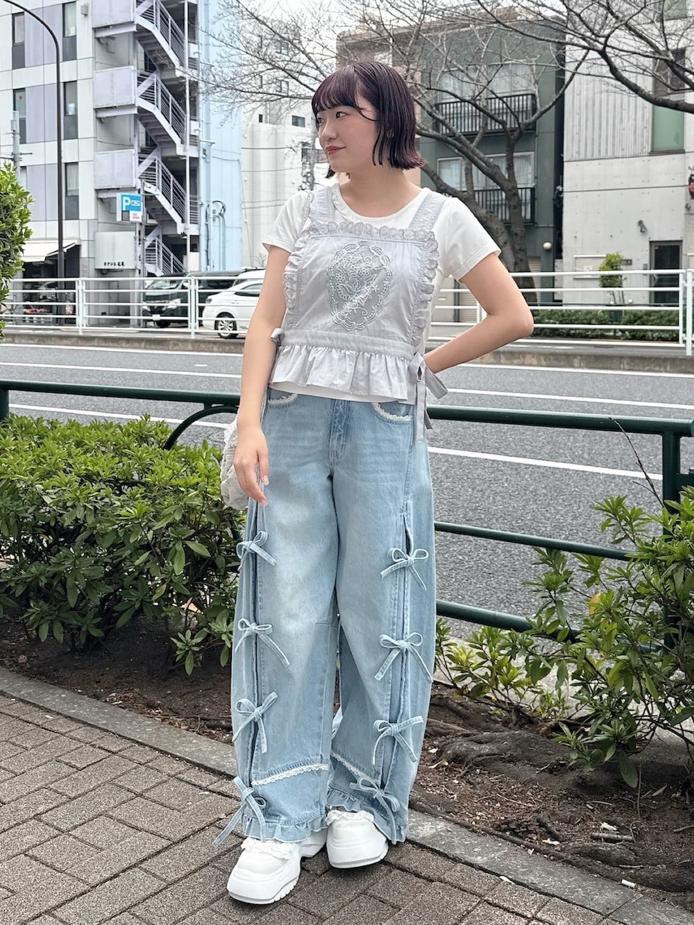 ブルー系のショルダーバッグ、ブルー系のシャツ/ブラウス、ホワイト系のTシャツ/カットソーを着用したレディースの春コーディネートの2枚目の写真