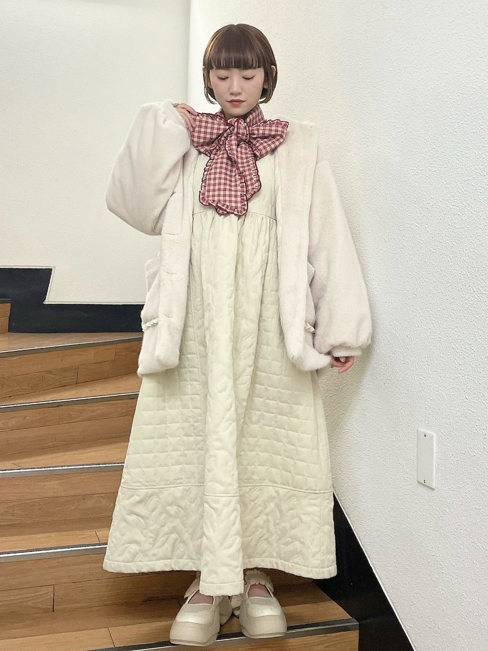 ホワイト系のダウンジャケット/コート、レッド系のシャツ/ブラウス、ホワイト系のワンピースを着用したレディースの冬コーディネートの2枚目の写真