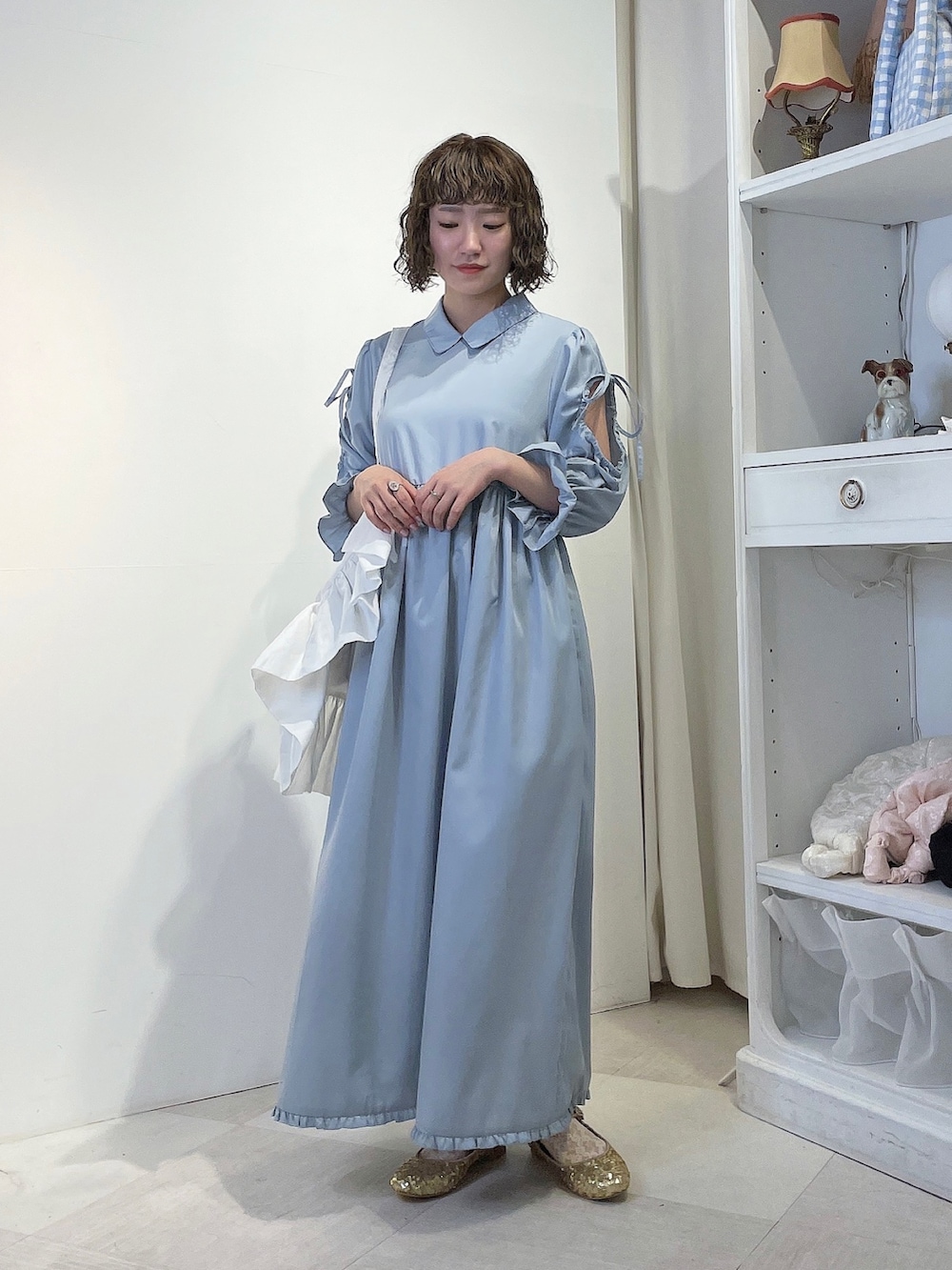 ホワイト系のトートバッグ、ブルー系のワンピース、ゴールド系のパンプスを着用したレディースの春コーディネートの2枚目の写真