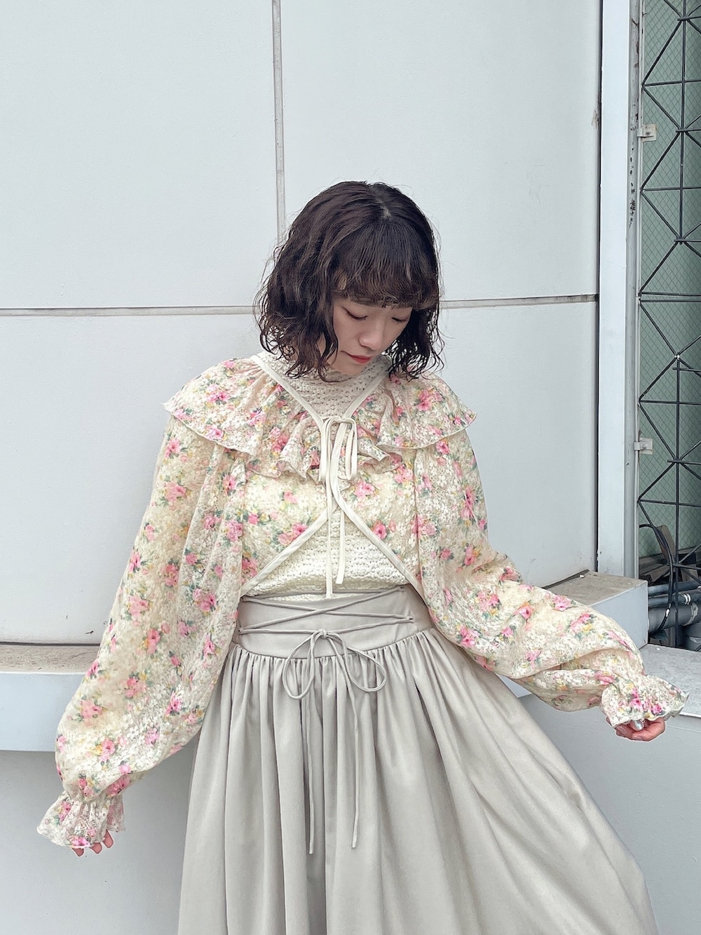 ホワイト系のカーディガン/ボレロ、ホワイト系のTシャツ/カットソー、ベージュ系のスカートを着用したレディースの冬コーディネートの5枚目の写真