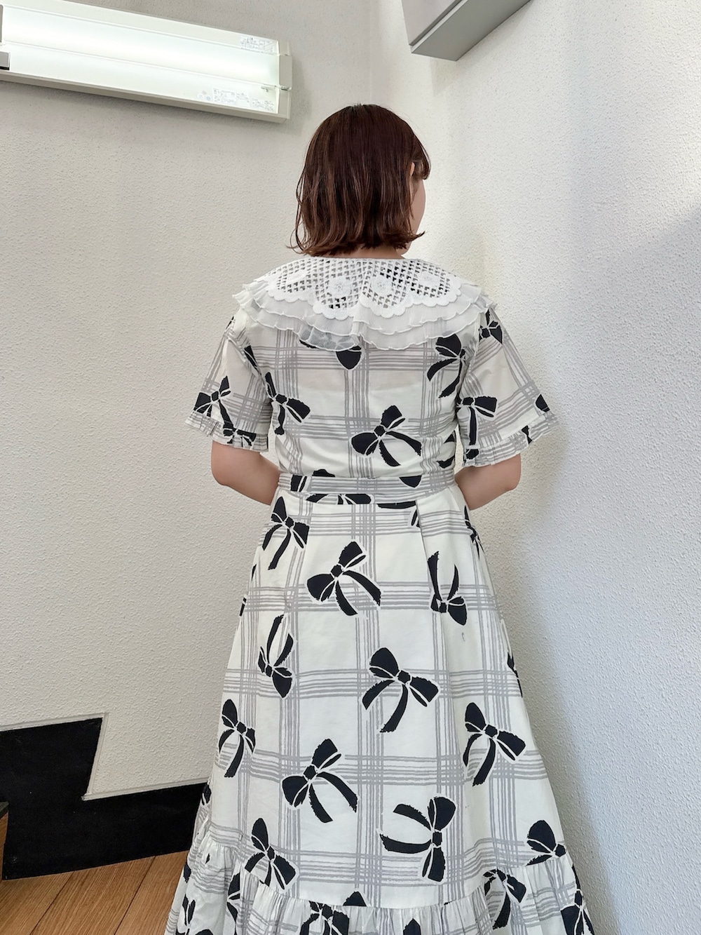 ホワイト系のワンピース、ブラック系のスニーカーを着用したレディースの冬コーディネートの5枚目の写真