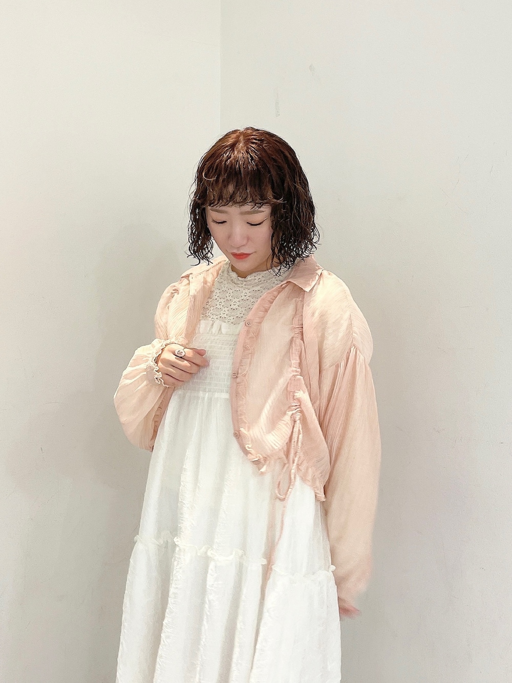 ホワイト系のワンピース、ピンク系のシャツ/ブラウス、ゴールド系のパンプスを着用したレディースの春コーディネートの4枚目の写真