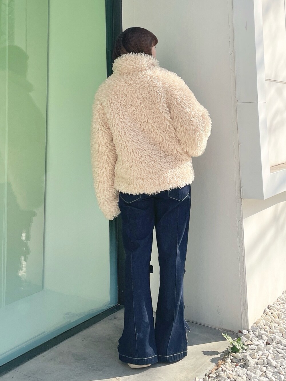 ホワイト系のダウンジャケット/コート、ブルー系のデニムパンツ、ホワイト系のスニーカーを着用したレディースの冬コーディネートの3枚目の写真