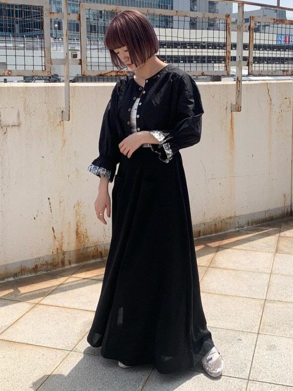 ブラック系のシャツ/ブラウス、ブラック系のスカート、ホワイト系のその他シューズを着用したレディースの春コーディネートの2枚目の写真