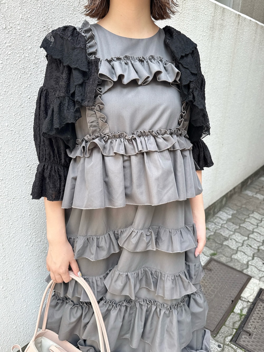 グレー系のワンピース、ブラック系のカーディガン/ボレロ、ピンク系のハンドバッグを着用したレディースの春コーディネートの8枚目の写真