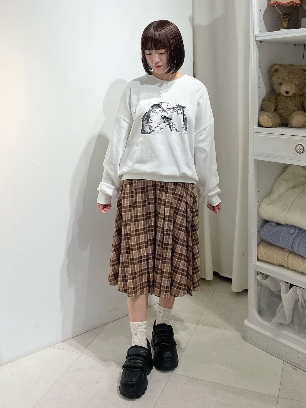 ブラウン系のスカート、ホワイト系のスウェット、ブラウン系のブルゾンを着用したレディースの秋コーディネートの6枚目の写真