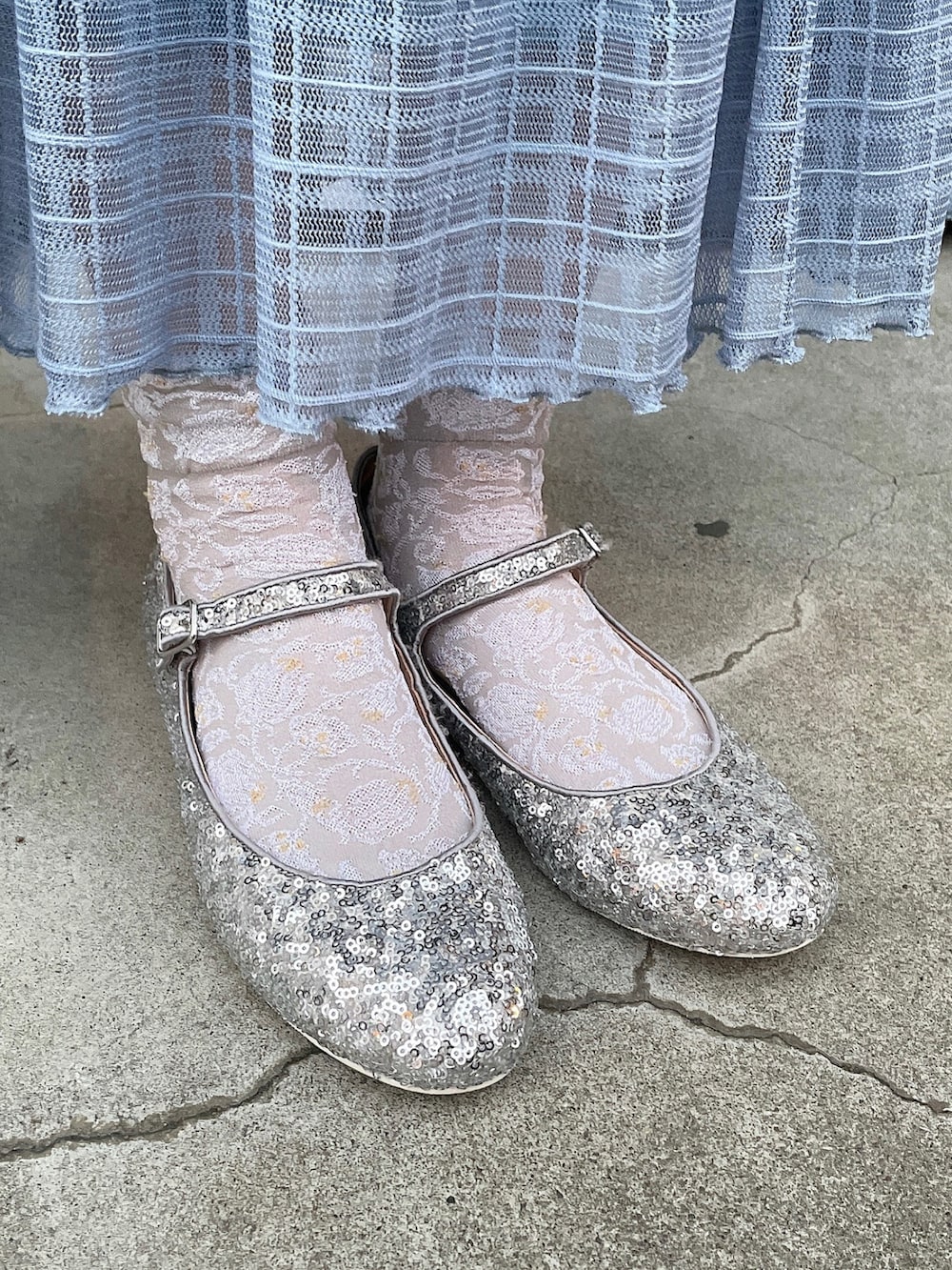 ブラック系のデニムジャケット、ブルー系のスカート、シルバー系のパンプスを着用したレディースの冬コーディネートの4枚目の写真