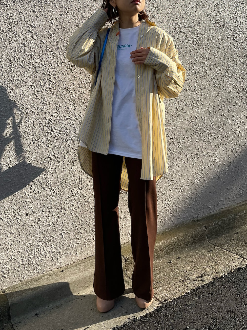 イエロー系のシャツ/ブラウス、ブラウン系のその他パンツ、ホワイト系のTシャツ/カットソーを着用したレディースの春コーディネートの3枚目の写真