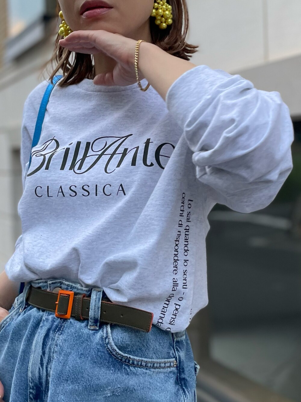 ベージュ系のTシャツ/カットソー、ブルー系のデニムスカートを着用したレディースの春コーディネートの5枚目の写真