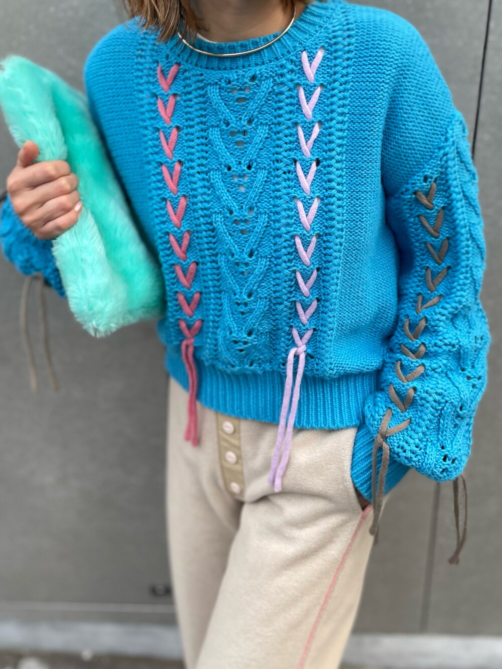 ブルー系のニット/セーター、ベージュ系のその他パンツ、ブラック系のブーツを着用したレディースの冬コーディネートの3枚目の写真