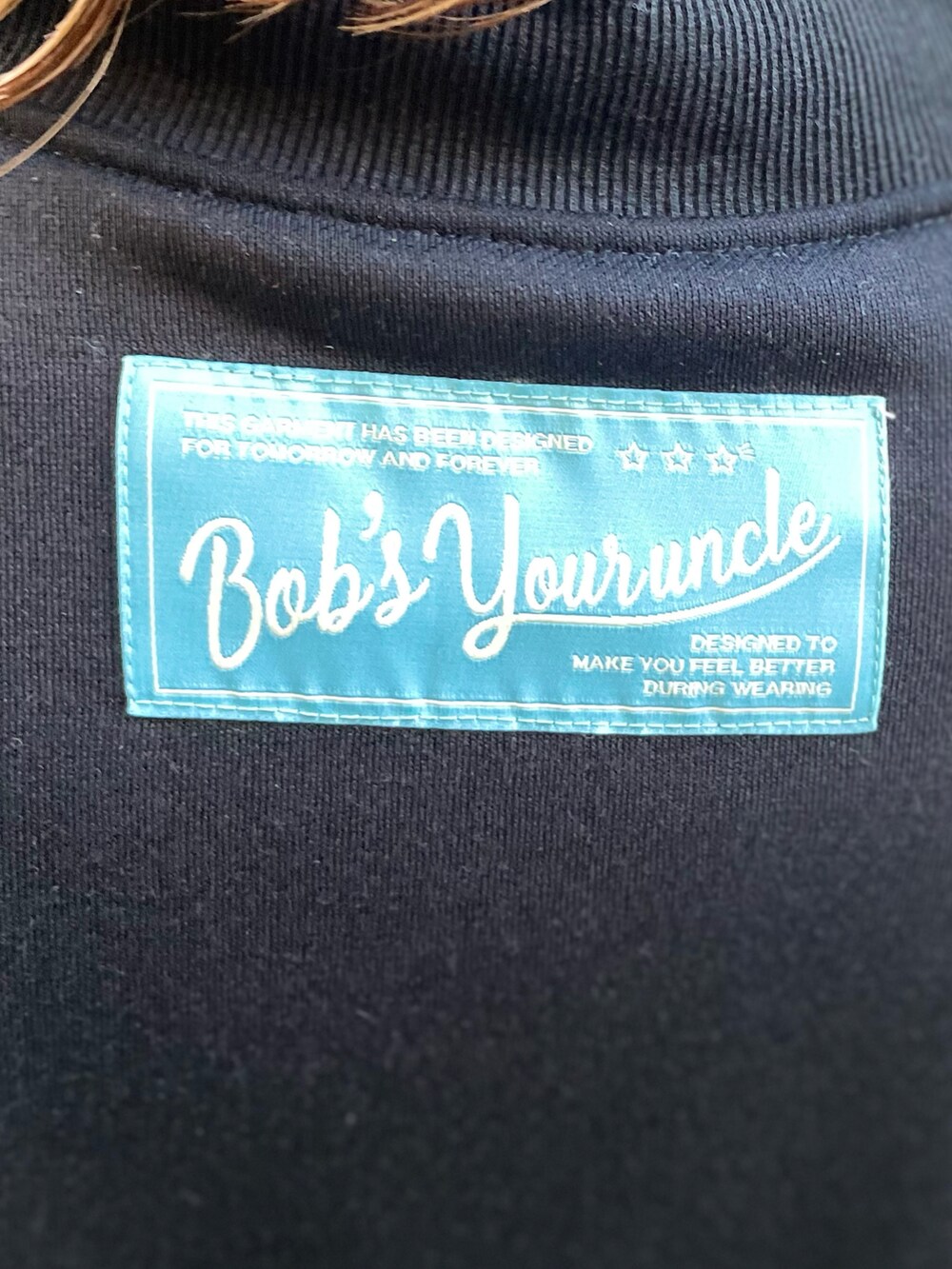 ブラック系のスウェット、ブルー系のデニムパンツを着用したレディースの秋コーディネートの5枚目の写真