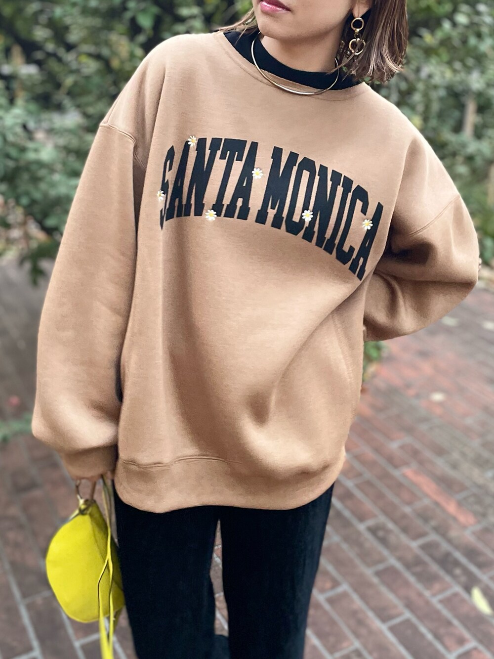 イエロー系のスウェット、ブラック系のその他パンツを着用したレディースの秋コーディネートの3枚目の写真