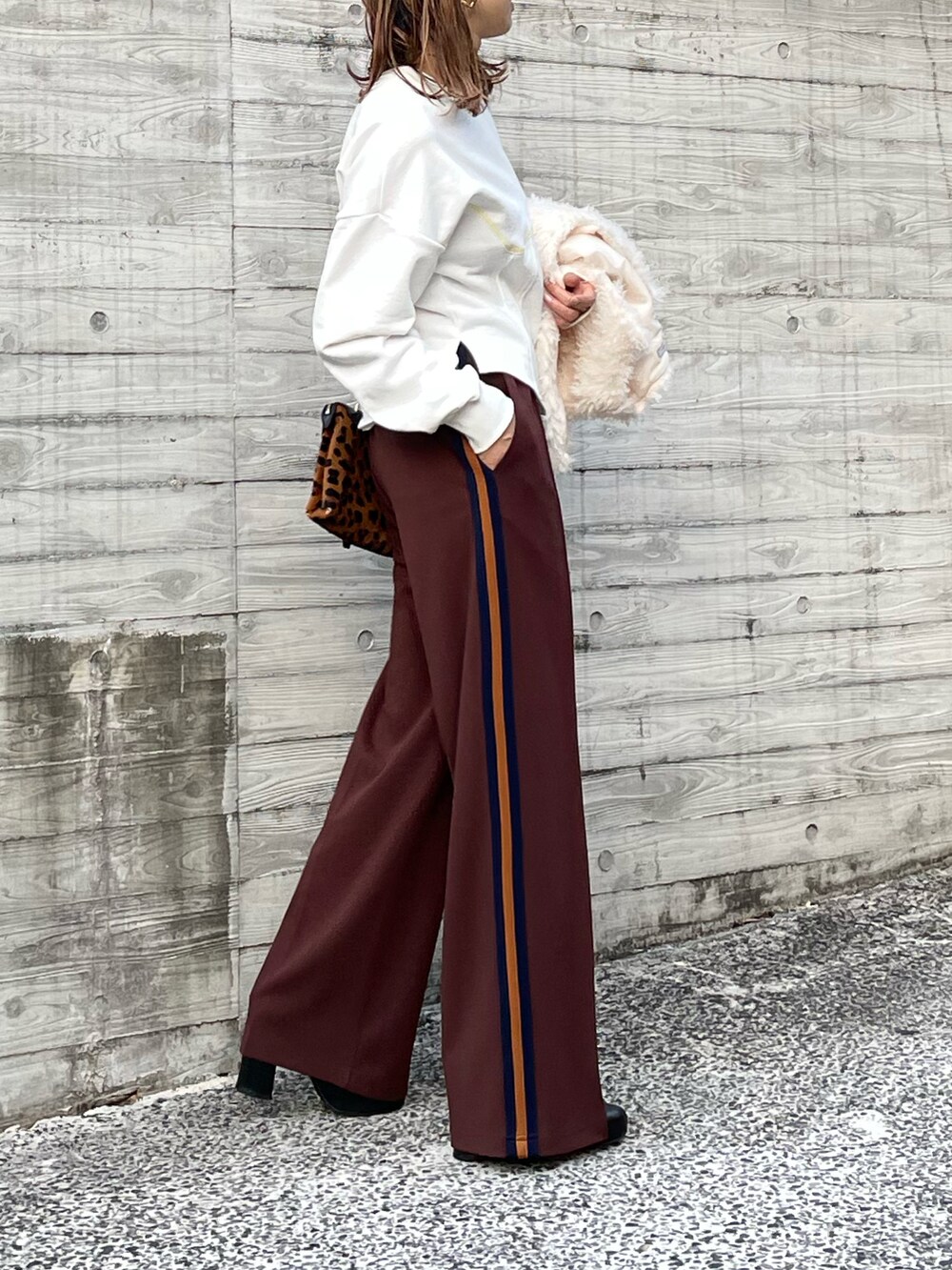 ホワイト系のベスト、ホワイト系のスウェット、ブラウン系のその他パンツを着用したレディースの秋コーディネートの5枚目の写真