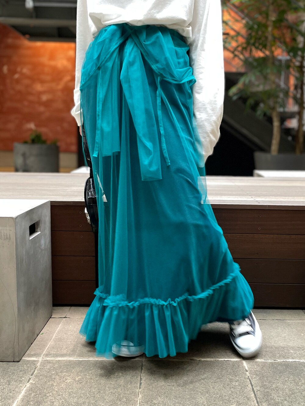 ホワイト系のTシャツ/カットソー、ブルー系のワンピース、ブラック系のスニーカーを着用したレディースの秋コーディネートの3枚目の写真