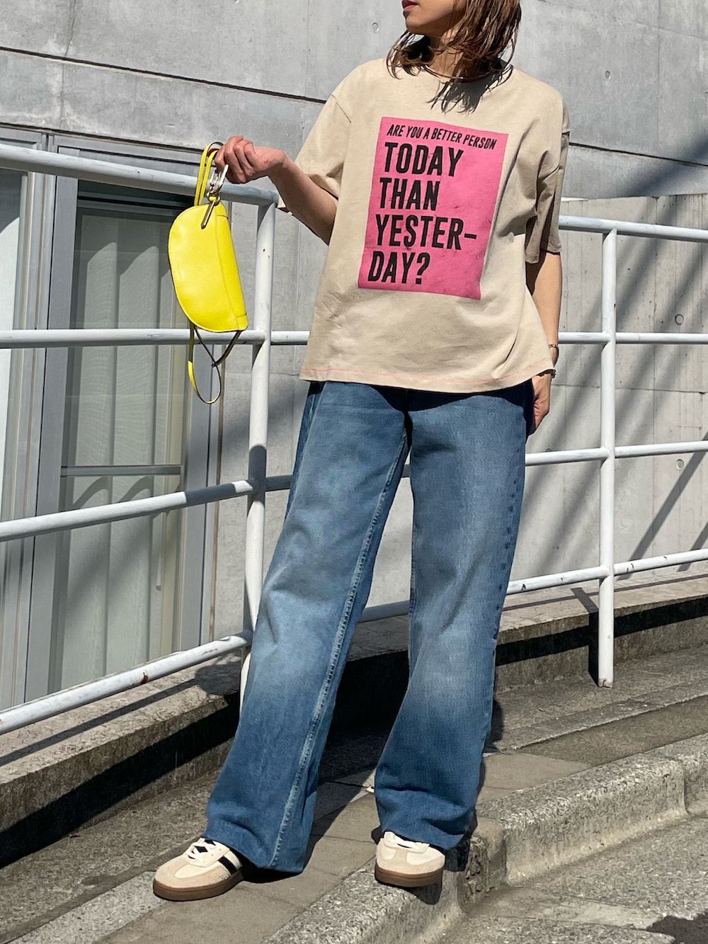 ベージュ系のTシャツ/カットソー、ブルー系のデニムパンツ、ホワイト系のスニーカーを着用したレディースの春コーディネートの5枚目の写真