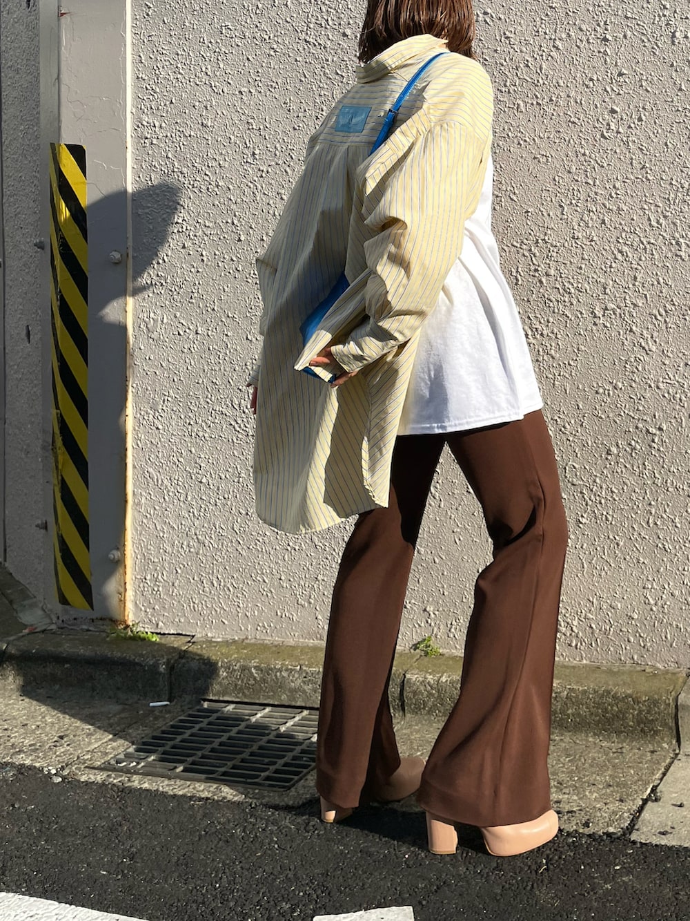 イエロー系のシャツ/ブラウス、ブラウン系のその他パンツ、ホワイト系のTシャツ/カットソーを着用したレディースの春コーディネートの5枚目の写真