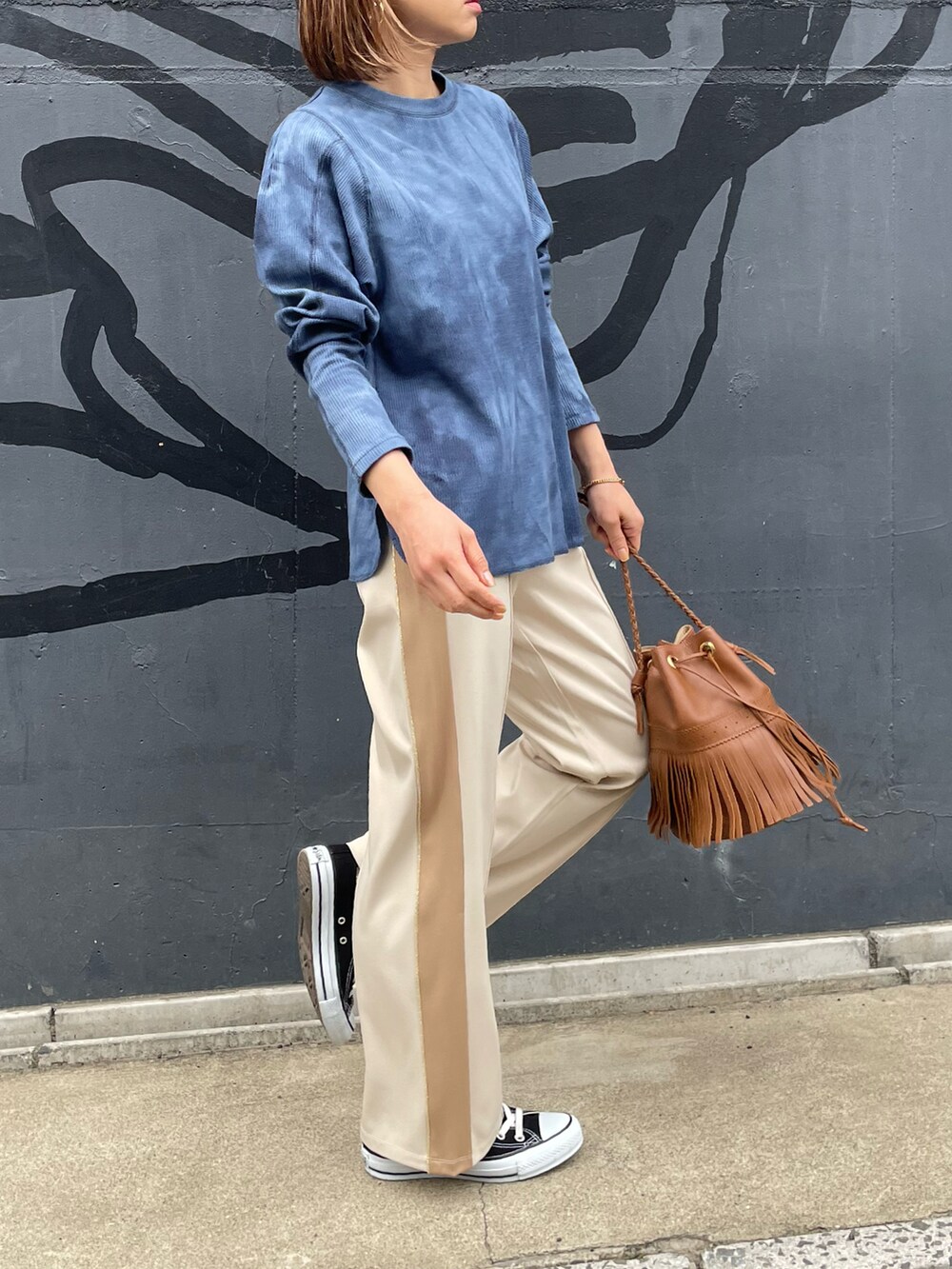 ホワイト系のその他パンツ、ブルー系のTシャツ/カットソー、ブラック系のスニーカーを着用したレディースの春コーディネートの3枚目の写真