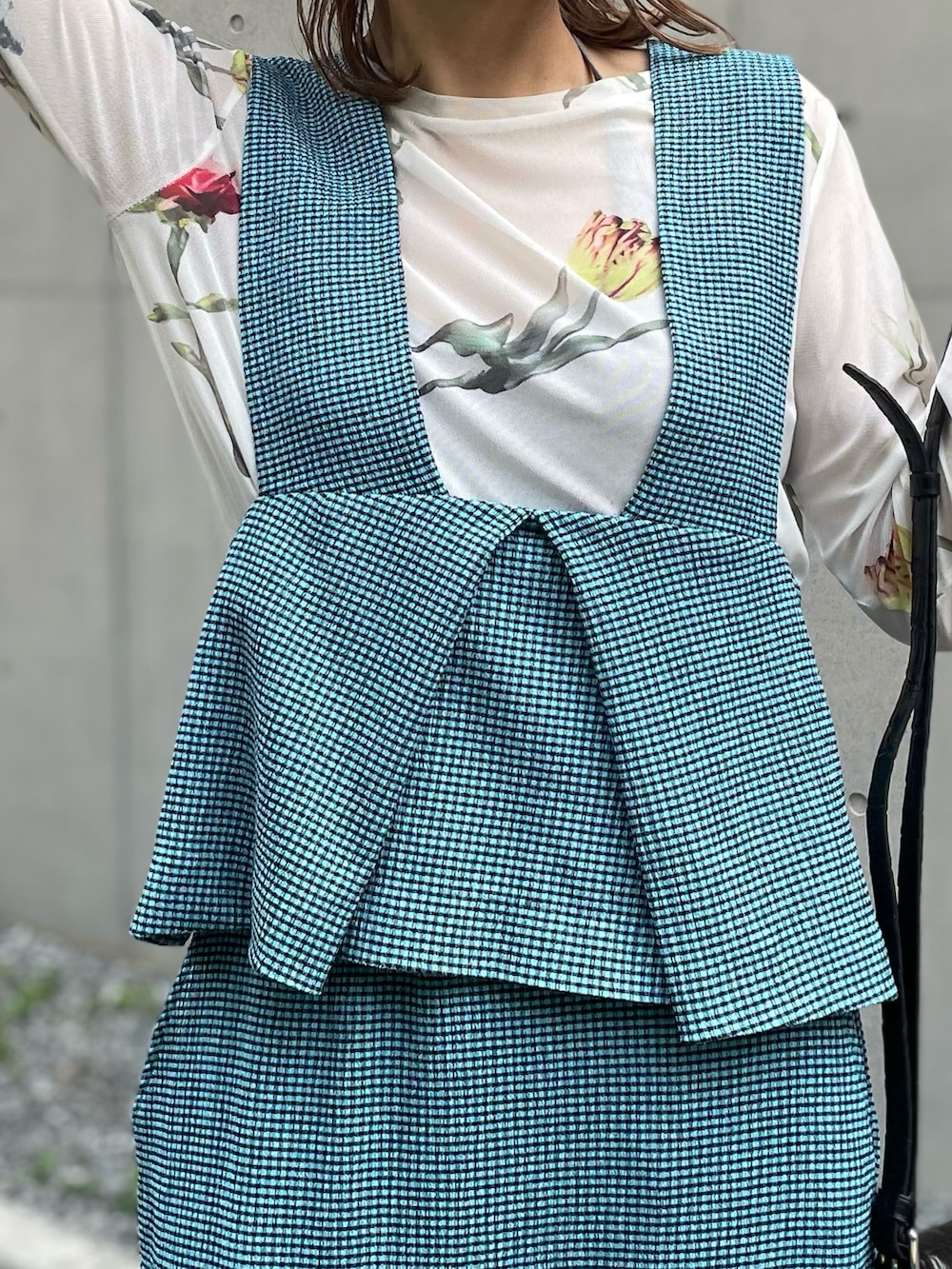 ブルー系のベスト、ブルー系のスカート、ホワイト系のTシャツ/カットソーを着用したレディースの夏コーディネートの3枚目の写真