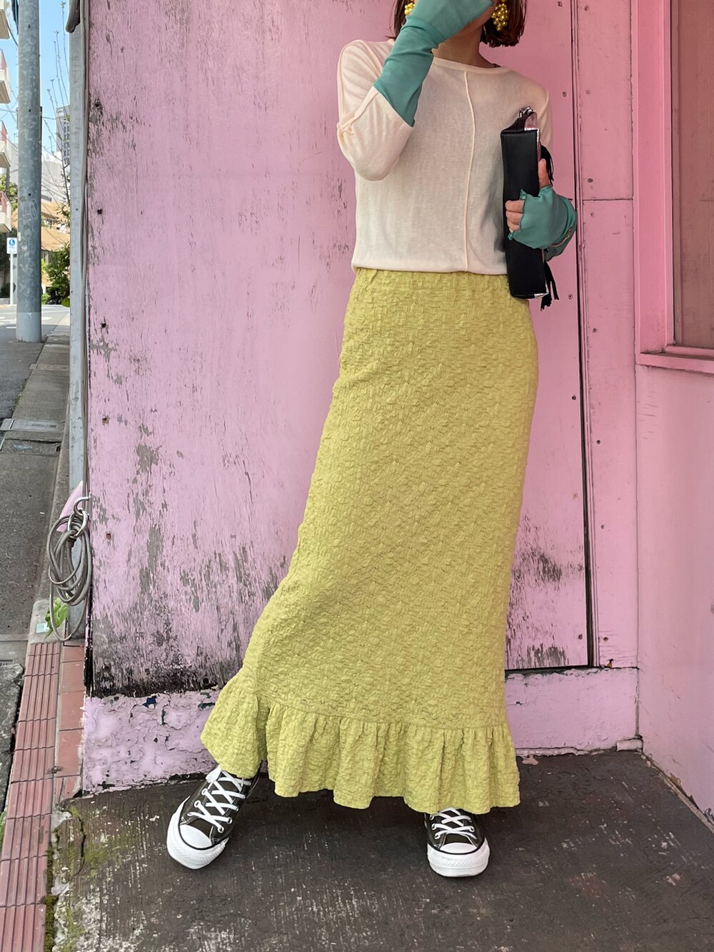 イエロー系のスカート、ベージュ系のTシャツ/カットソー、グリーン系のスニーカーを着用したレディースの春コーディネートの4枚目の写真