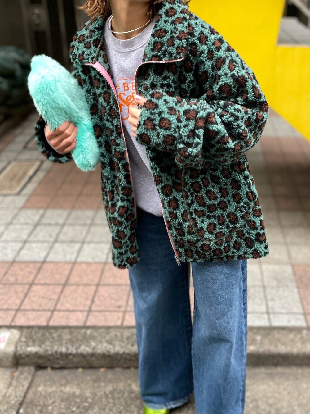 ブルー系のブルゾン、グレー系のスウェット、ブルー系のデニムパンツを着用したレディースの冬コーディネートの2枚目の写真