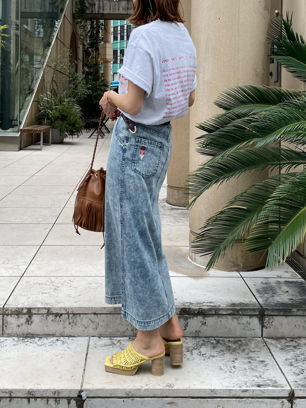 ベージュ系のTシャツ/カットソー、ブルー系のデニムスカートを着用したレディースの夏コーディネートの5枚目の写真