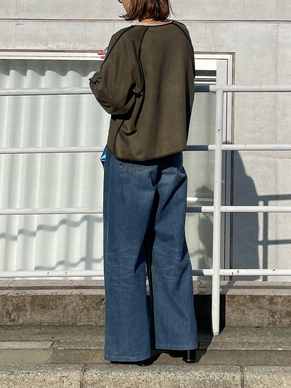 グリーン系のノーカラージャケット、ベージュ系のTシャツ/カットソーを着用したレディースの冬コーディネートの5枚目の写真