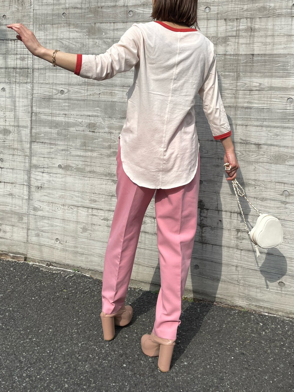 オレンジ系のTシャツ/カットソー、ピンク系のパンツを着用したレディースの春コーディネートの4枚目の写真