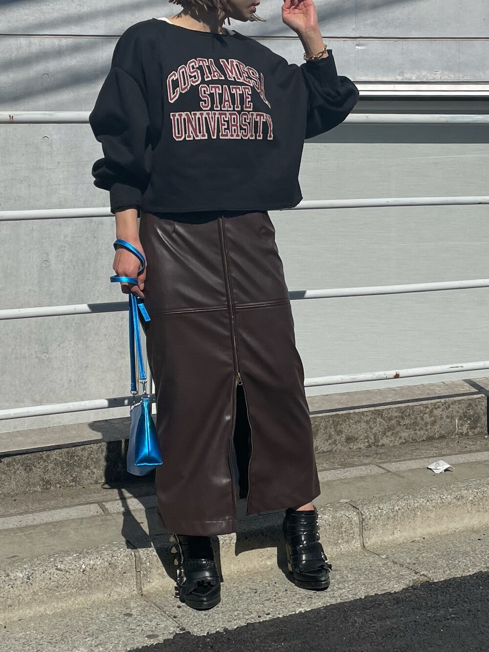 ブラック系のスウェット、ブラウン系のスカート、ホワイト系のタンクトップを着用したレディースの冬コーディネートの2枚目の写真