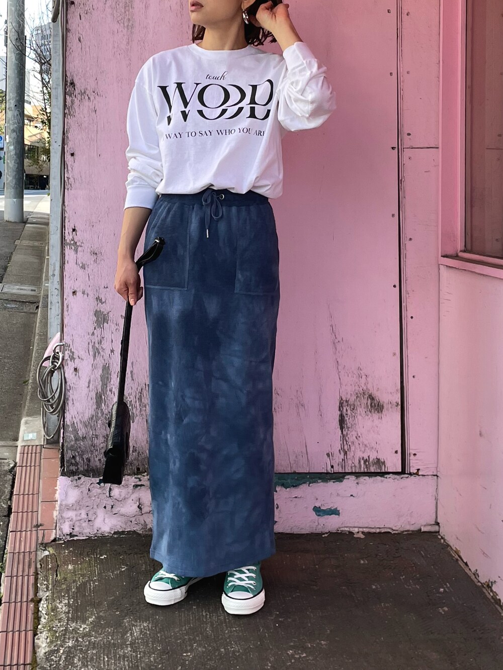 ブルー系のスカート、グリーン系のスニーカー、ホワイト系のTシャツ/カットソーを着用したレディースの春コーディネートの4枚目の写真