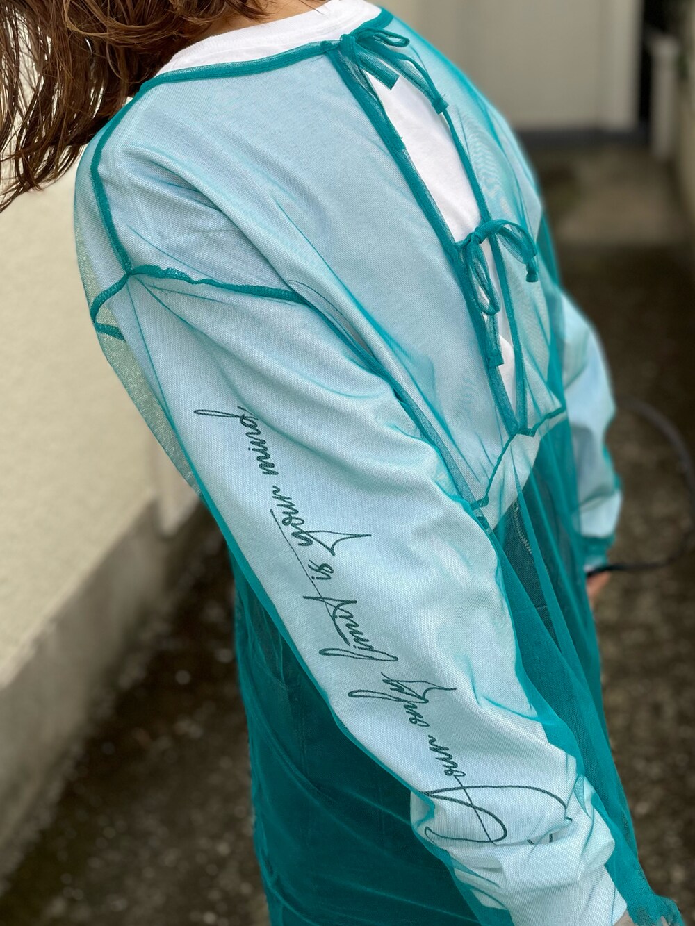 ブルー系のワンピース、ホワイト系のTシャツ/カットソー、ブラック系のスニーカーを着用したレディースの秋コーディネートの3枚目の写真