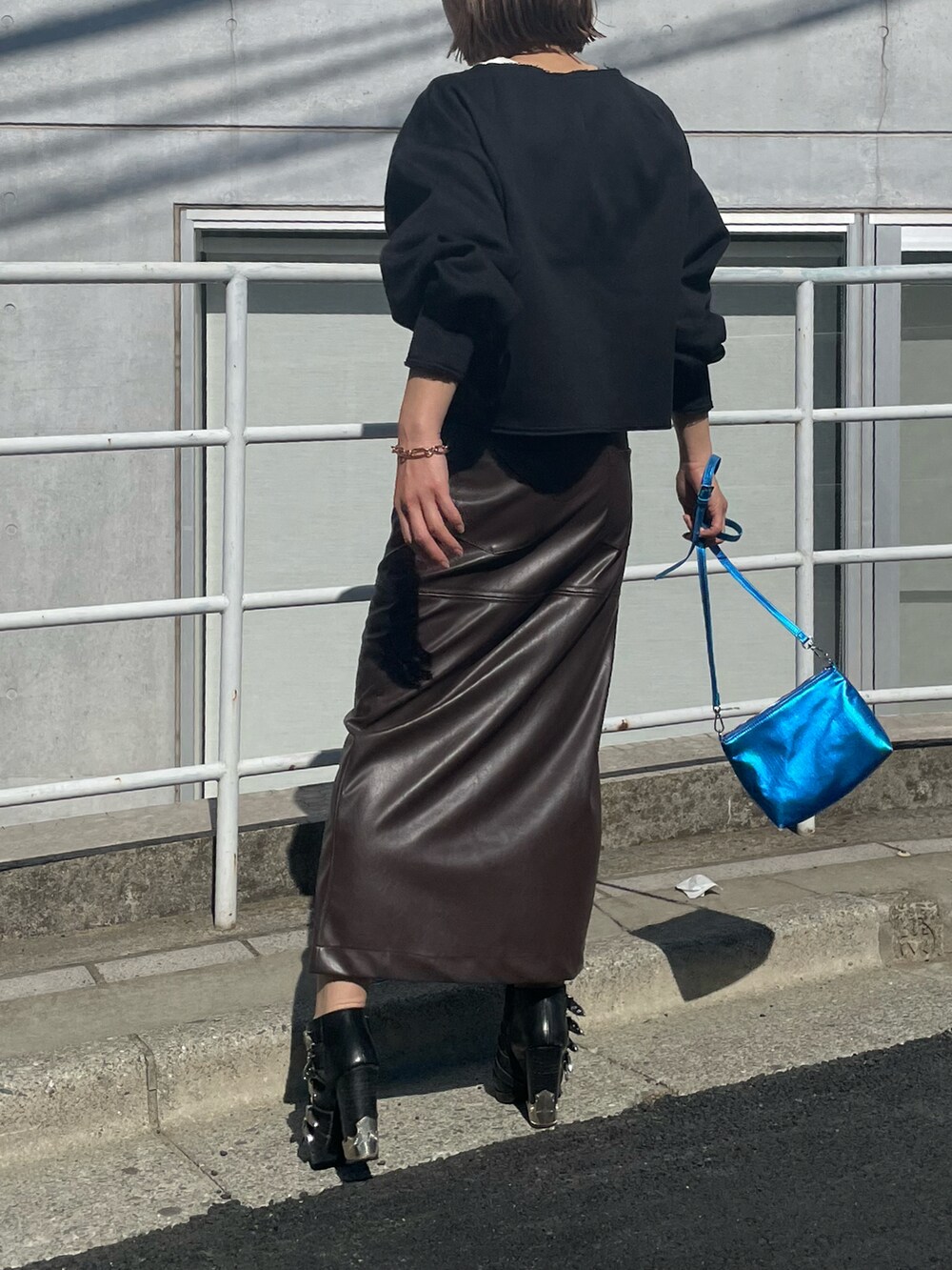 ブラック系のスウェット、ブラウン系のスカート、ホワイト系のタンクトップを着用したレディースの冬コーディネートの4枚目の写真