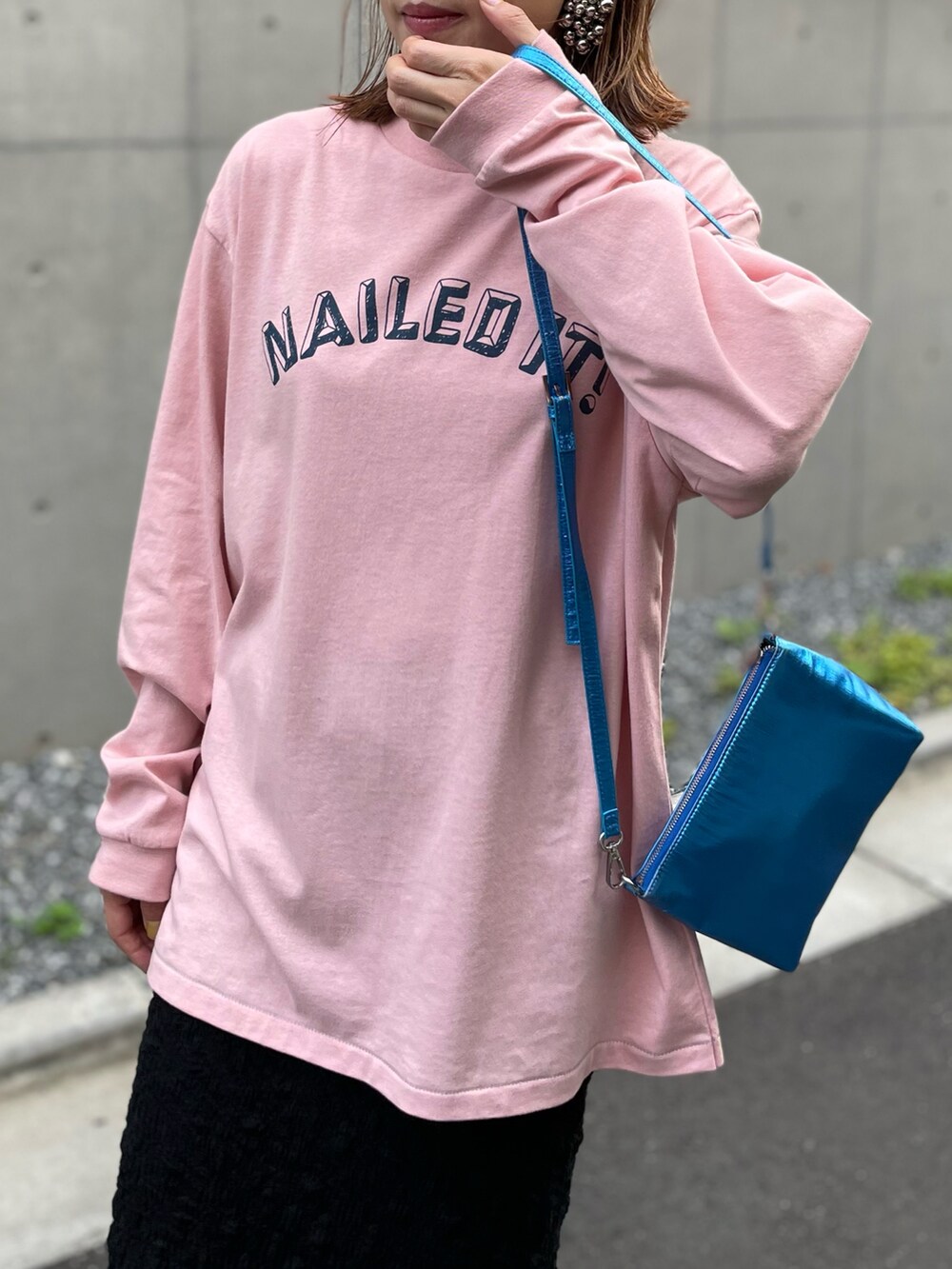 ピンク系のTシャツ/カットソー、ブラック系のスカート、ピンク系のスニーカーを着用したレディースの夏コーディネートの3枚目の写真