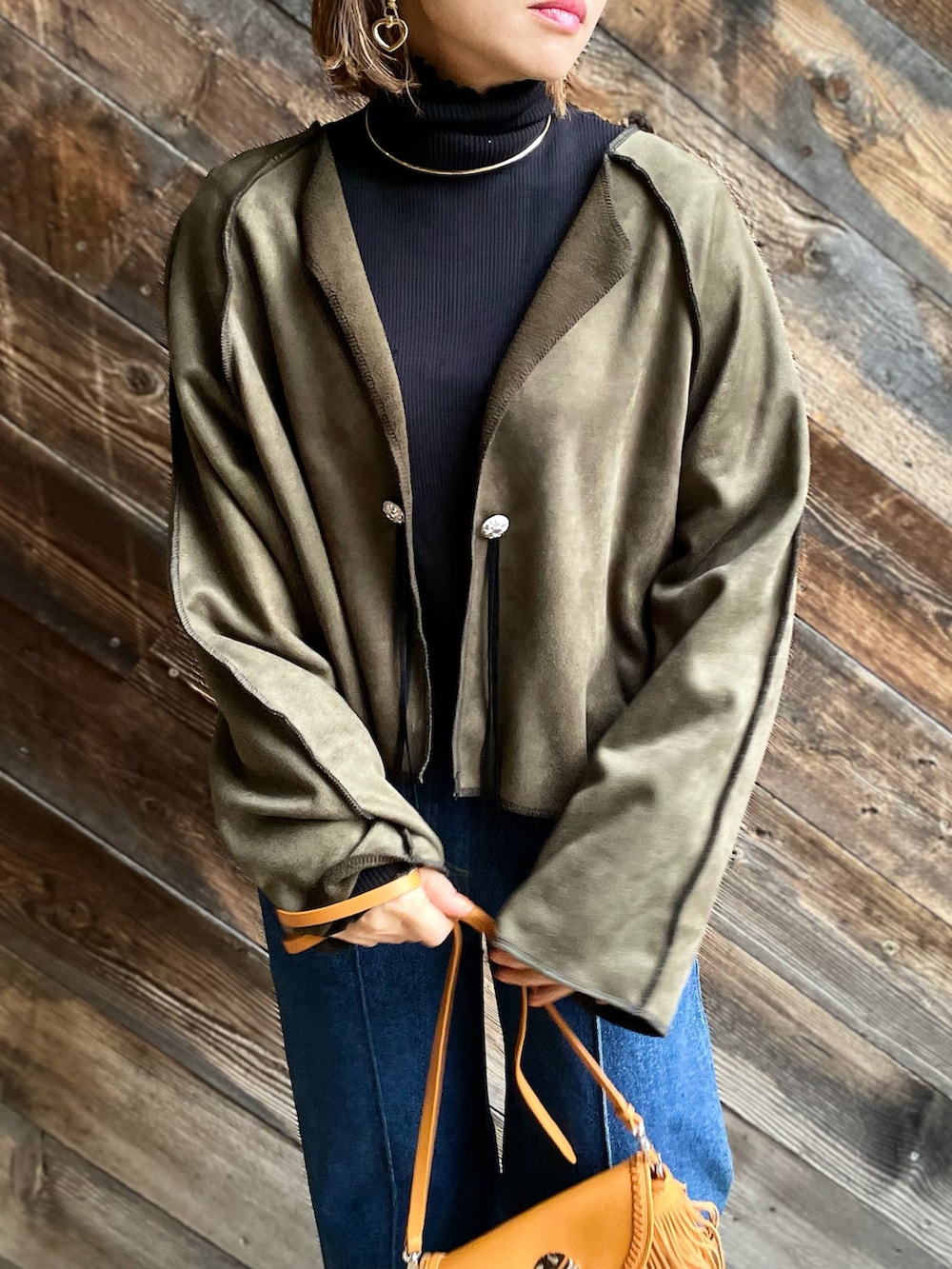 グリーン系のノーカラージャケット、ブルー系のネックウォーマー/スヌードを着用したレディースの秋コーディネートの3枚目の写真