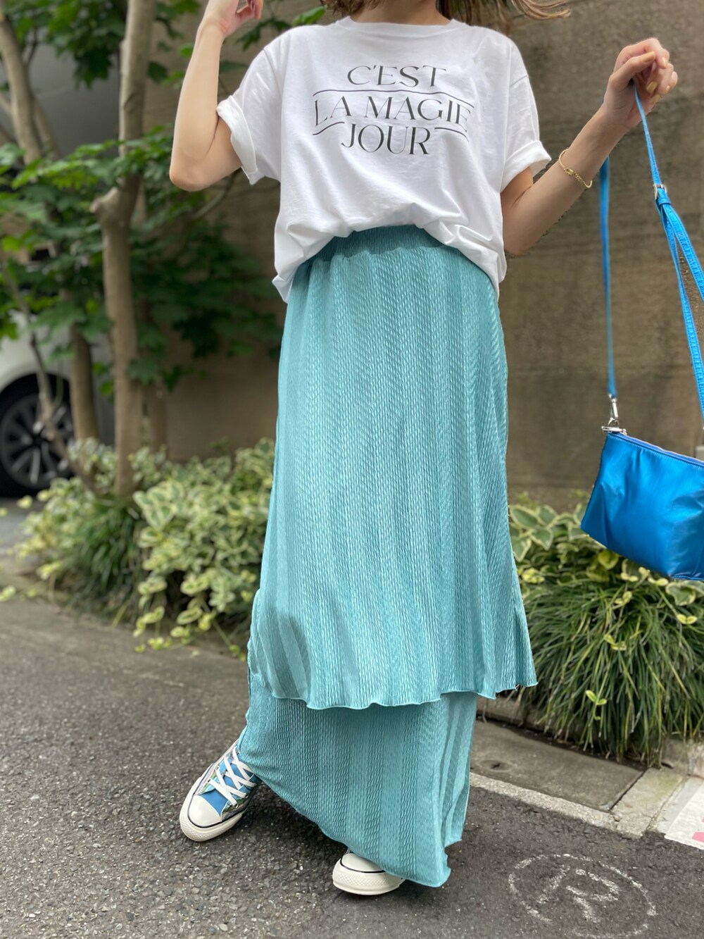 ブルー系のスカート、ホワイト系のTシャツ/カットソー、ブルー系のスニーカーを着用したレディースの夏コーディネートの2枚目の写真
