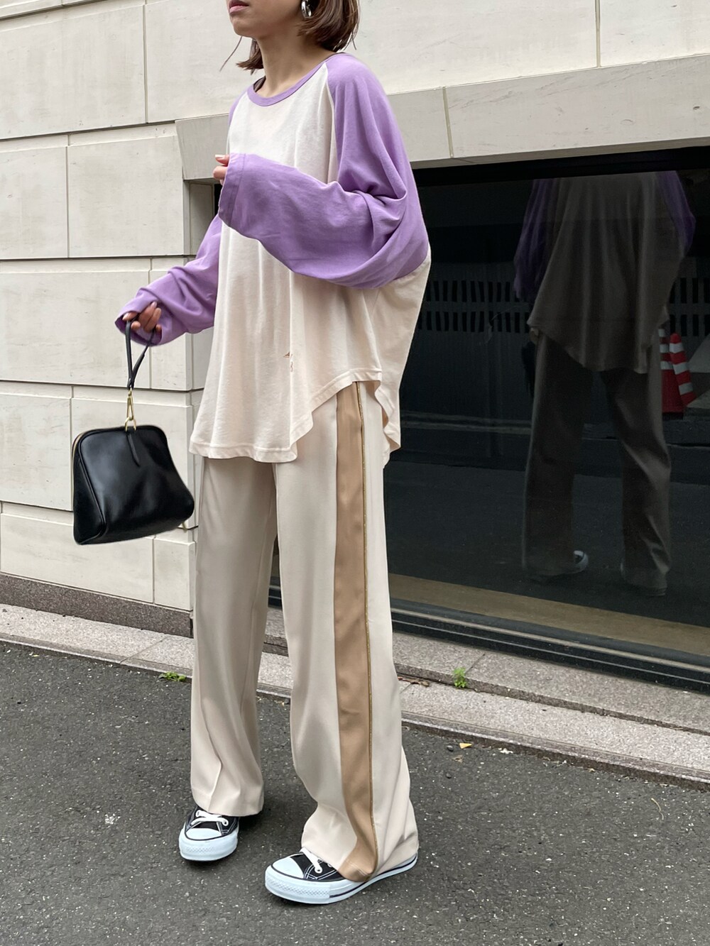 パープル系のTシャツ/カットソー、ブラウン系のタンクトップ、ホワイト系のパンツを着用したレディースの春コーディネートの5枚目の写真