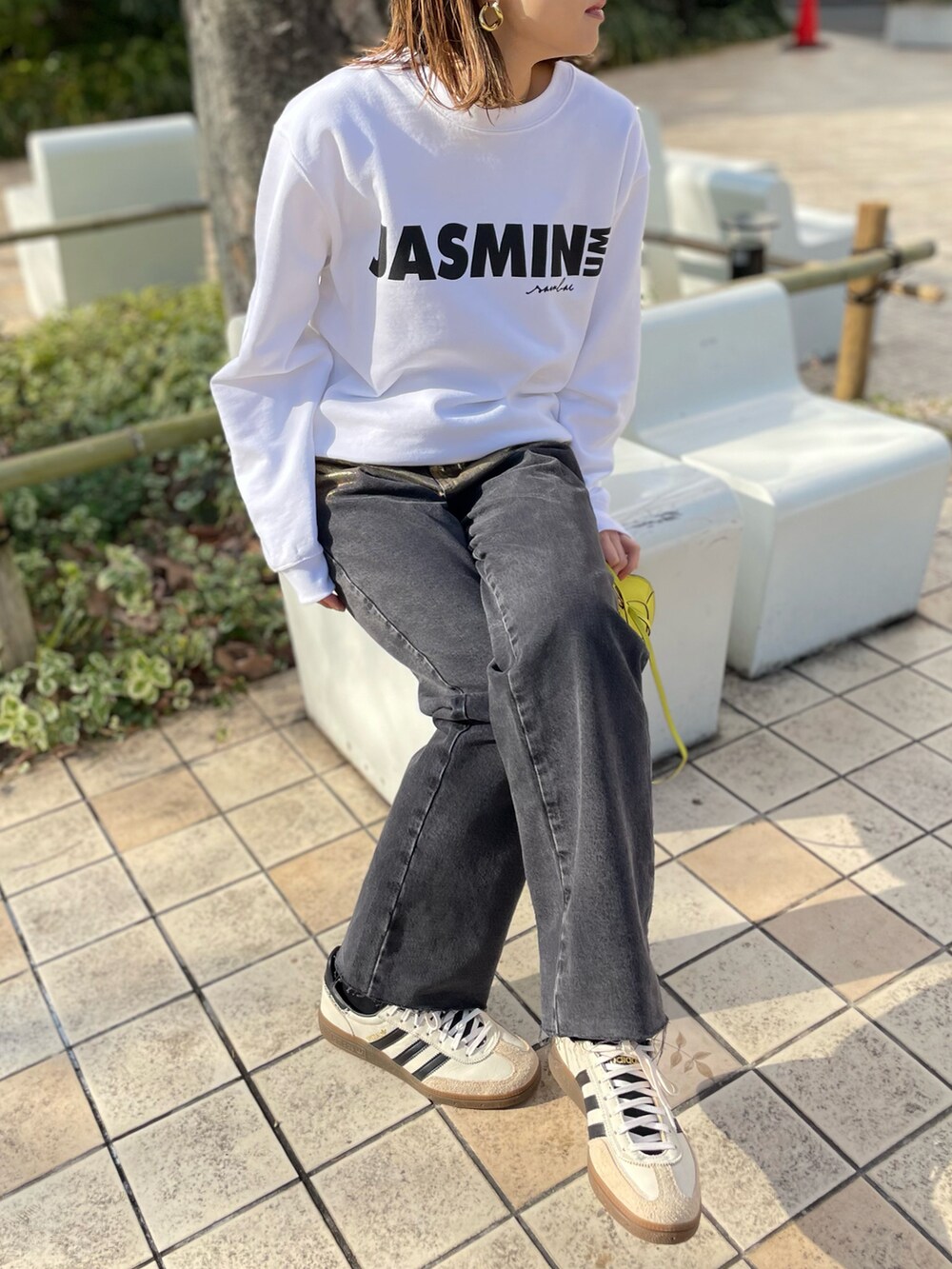 ホワイト系のスウェット、ブラック系のデニムパンツ、ホワイト系のスニーカーを着用したレディースの冬コーディネートの4枚目の写真